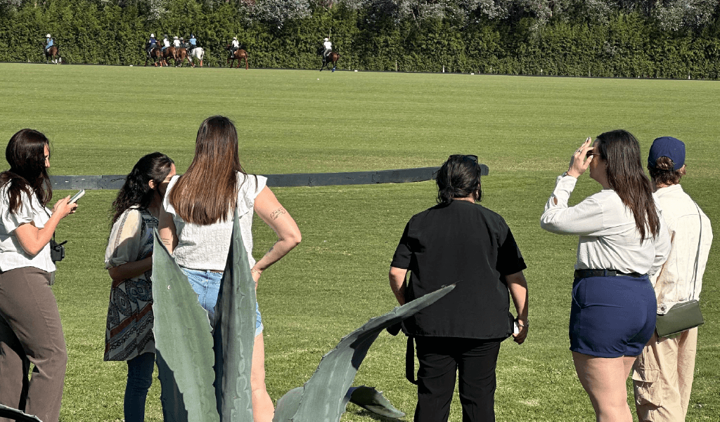 Participantes observan la práctica desde el borde de cancha.